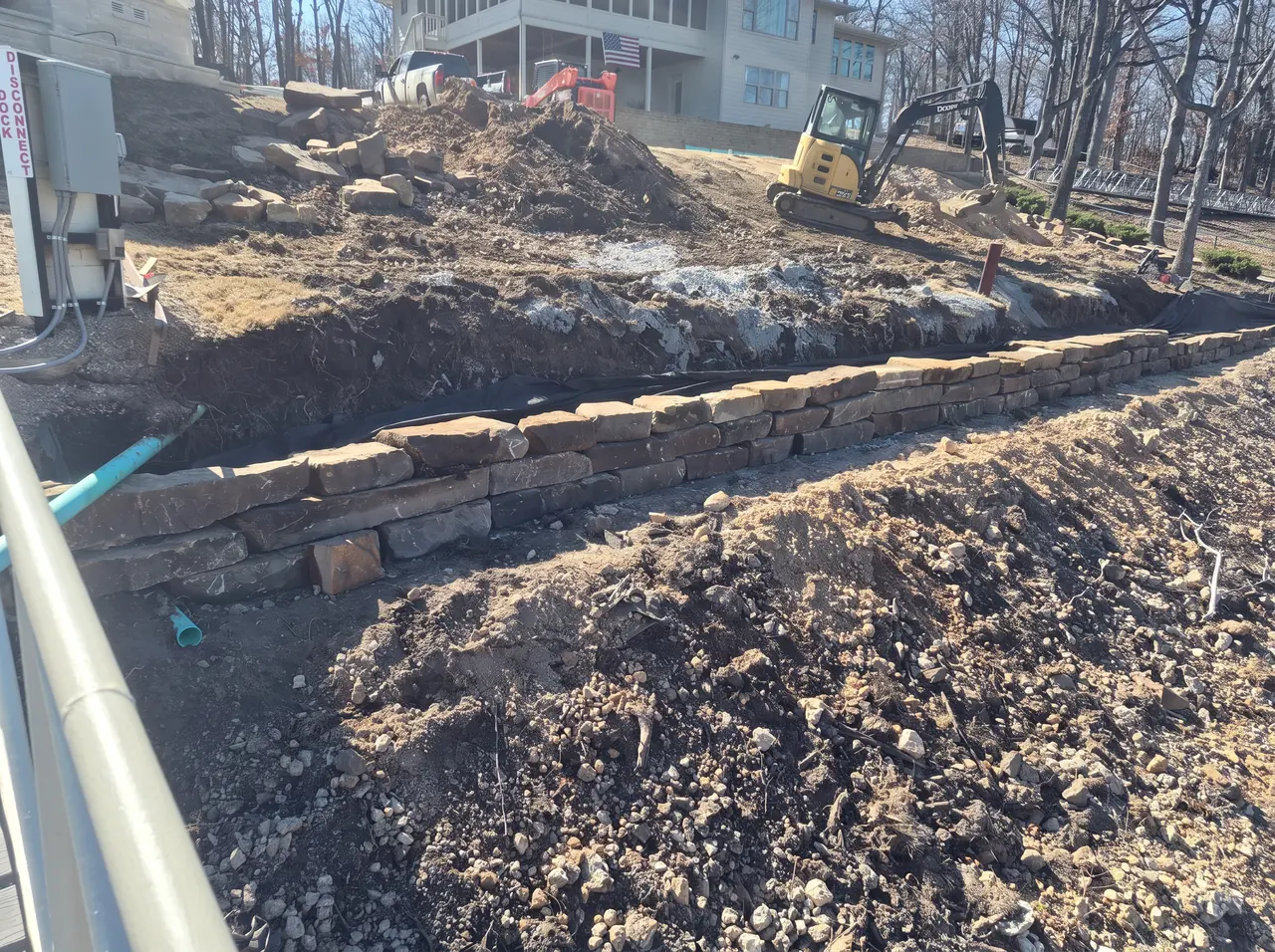 Grand Lake Seawall Rebuild — Finished stone retaining wall at the waterline.