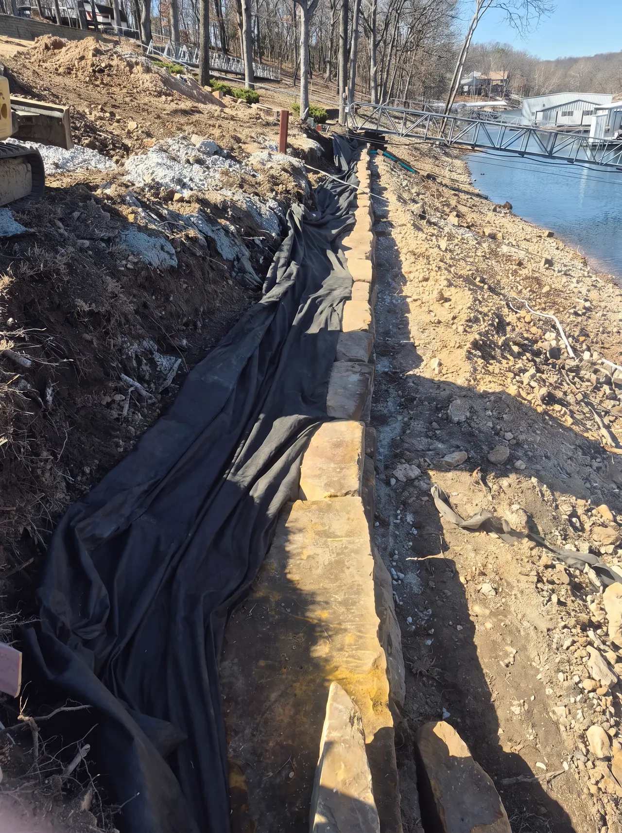 Grand Lake Seawall Rebuild — Base course and drainage fabric installed.